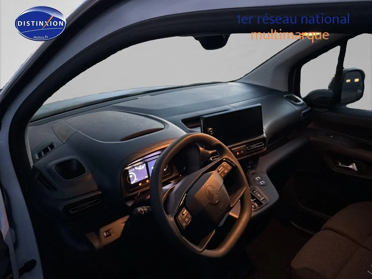 Vue intérieure côté conducteur du Citroën Berlingo Fourgon blanc 2025, tableau de bord et volant multifonctions visibles.