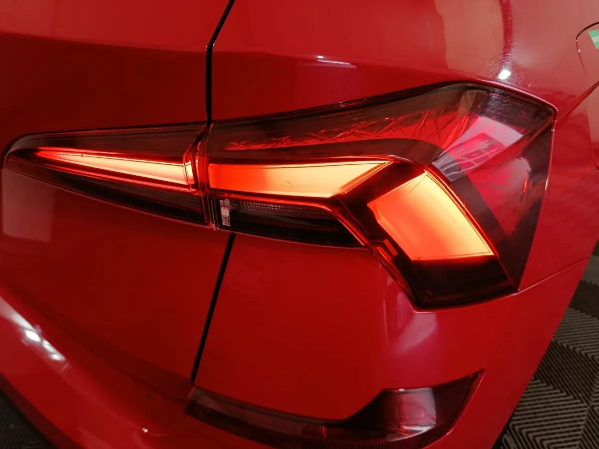Gros plan sur le feu arrière droit rouge vif du Skoda Kamiq 2024, soulignant ses lignes modernes et anguleuses.
