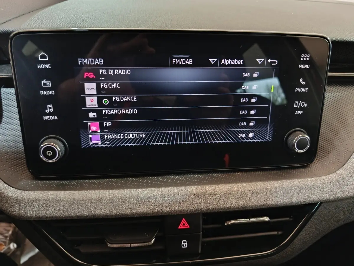 Écran tactile central 8,25 pouces du tableau de bord du Skoda Kamiq 2024, affichant les stations radio FM/DAB.