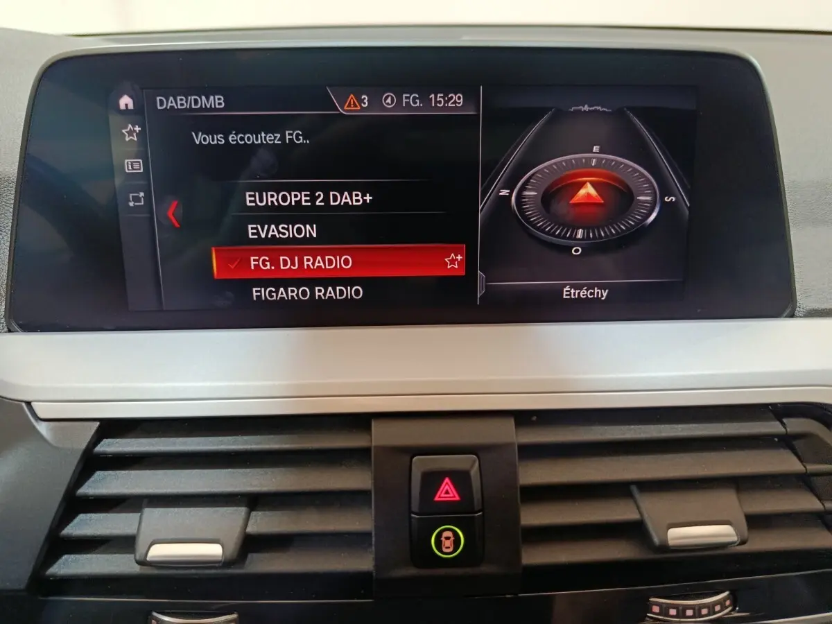 Écran central de navigation et radio du BMW X3 xDrive30e 2020, affichant stations DAB+ et boussole numérique.