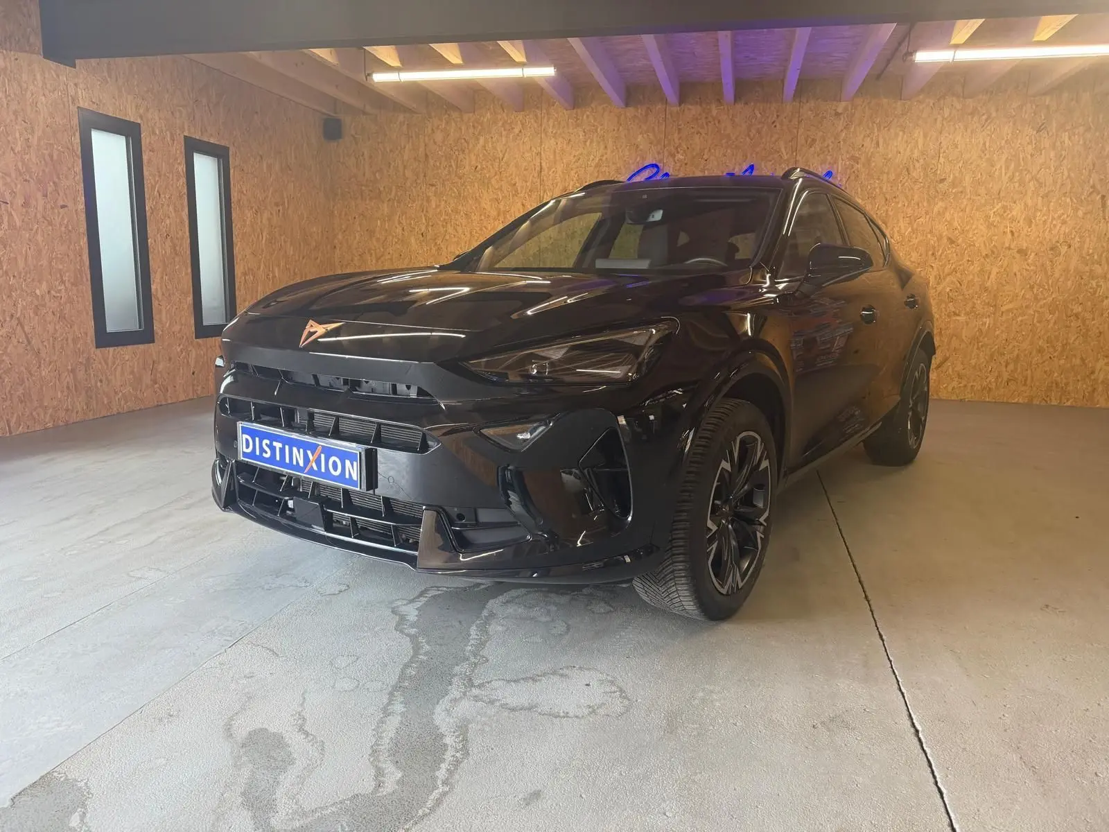 Vue 3/4 avant droite d'un CUPRA Formentor noir 2025 avec jantes alliage et calandre marquée du logo cuivre.