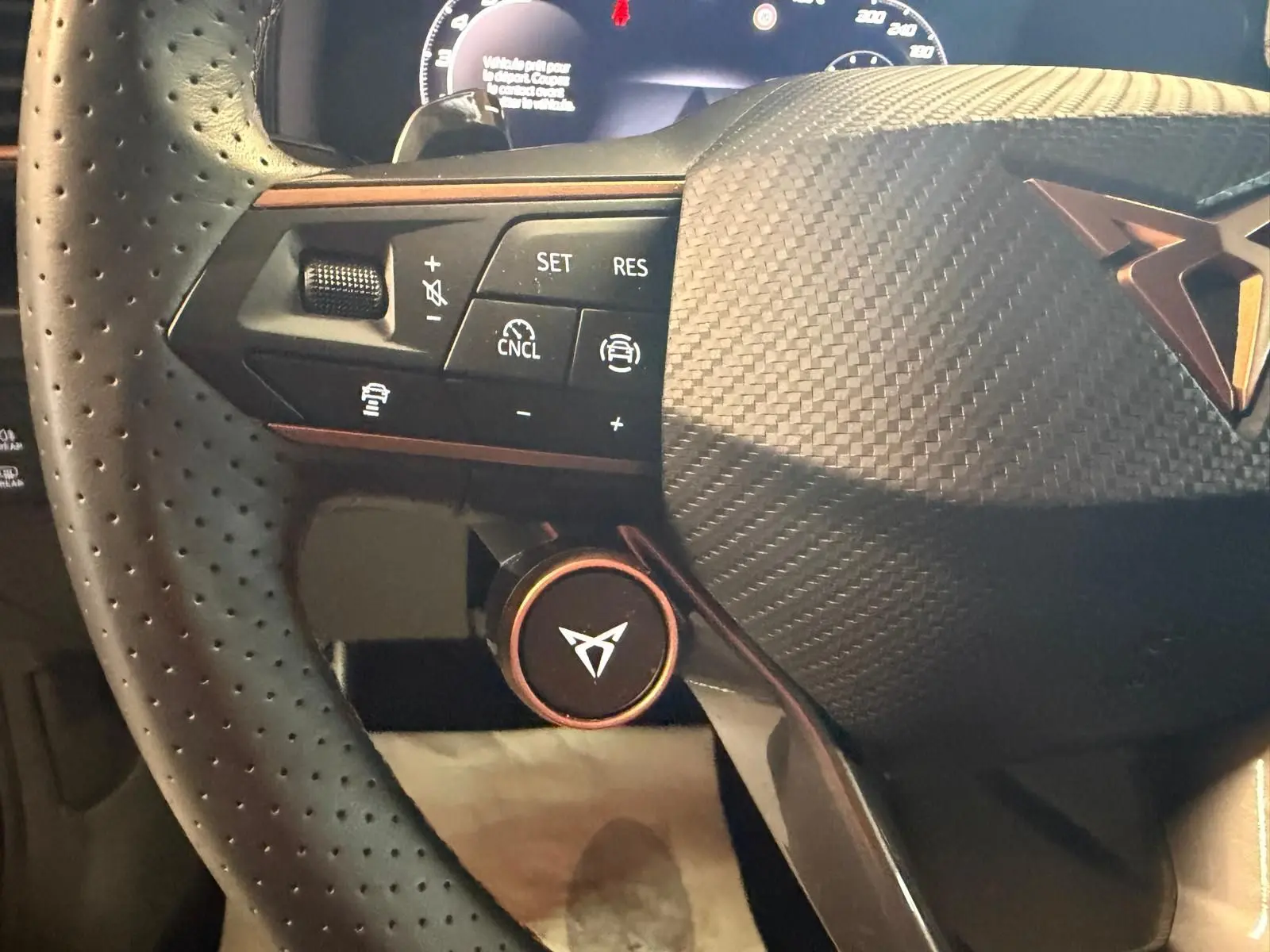 Gros plan sur le volant cuir perforé noir du CUPRA Formentor 2.0 TDI 150 DSG avec commandes intégrées et logo central.