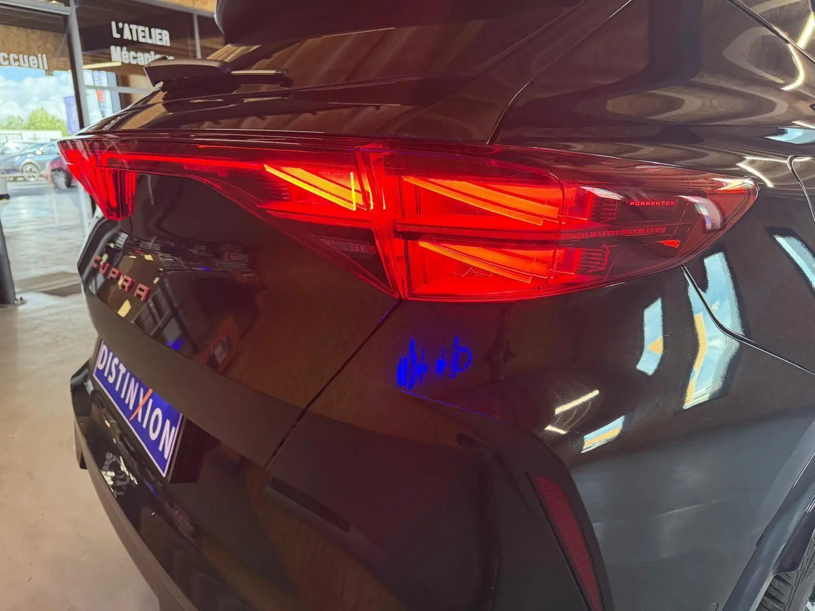 Vue 3/4 arrière droite d'une CUPRA Formentor noire 2025, mettant en valeur ses feux arrière LED et le hayon fermé.