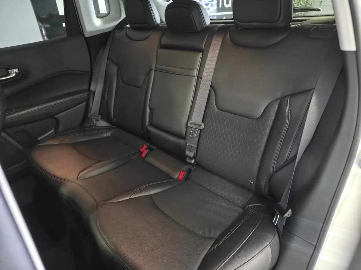 Vue intérieure sur la banquette arrière en simili cuir noir du Jeep Compass 2020 avec ceintures et appuie-têtes.