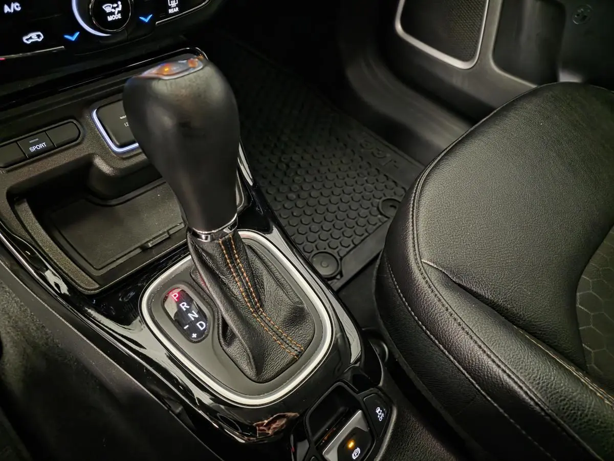 Le levier de vitesse automatique noir du Jeep Compass 2020, avec coutures orange et siège simili cuir adjacent.