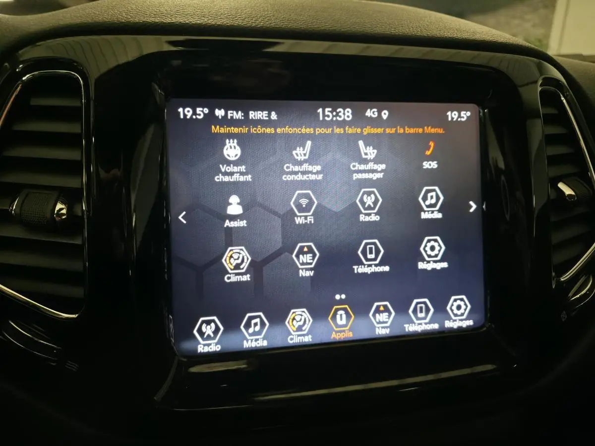 Écran tactile central du Jeep Compass 2020 affichant les commandes de climatisation et multimédia, entouré de finition noire brillante.