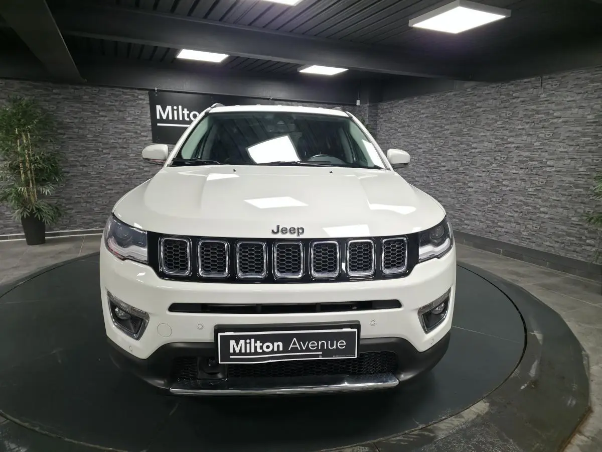 Vue frontale d'un Jeep Compass blanc Alpine White avec calandre à sept fentes et plaque Milton Avenue.