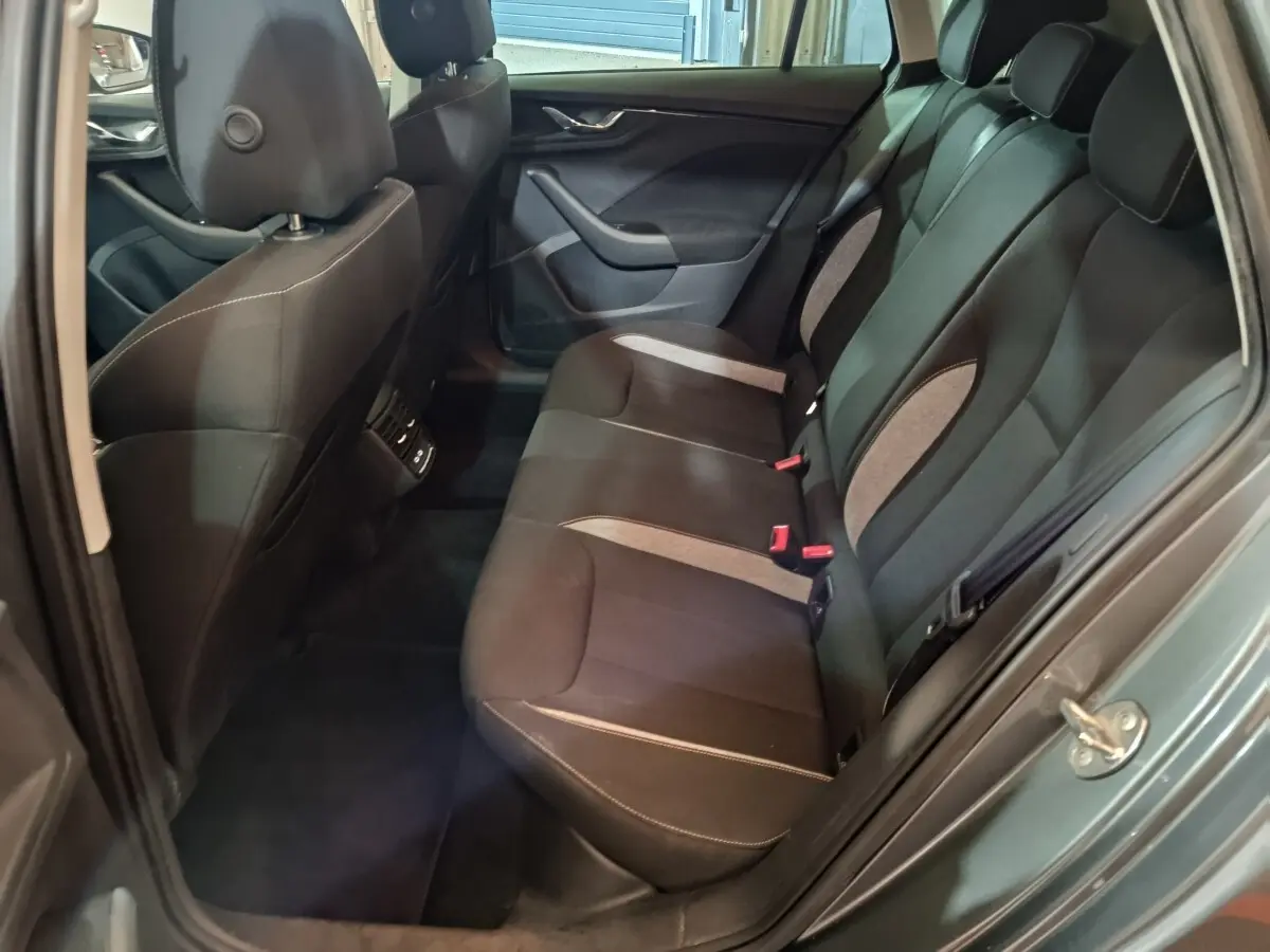 Vue intérieure arrière côté droit du Skoda Kamiq gris clair 2024, banquette 3 places avec sièges noirs et inserts gris.