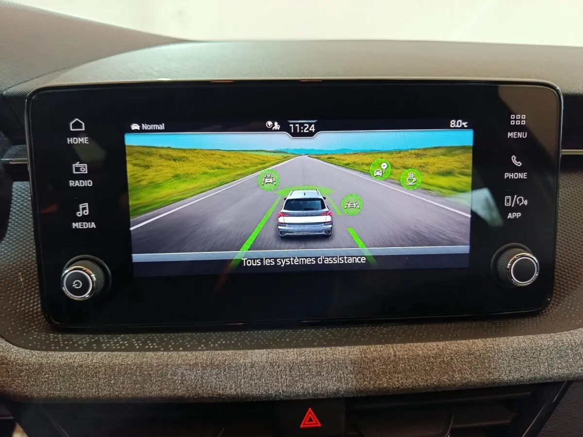 Écran tactile central affichant l'aide à la conduite avec vue arrière d'un Skoda Kamiq gris clair.