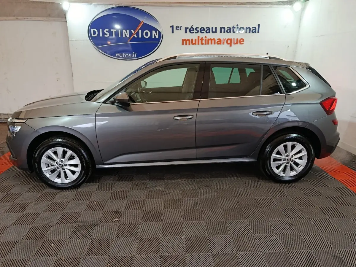 Vue latérale droite d'un Skoda Kamiq gris clair 2024, avec rails de toit noirs et jantes alliage.