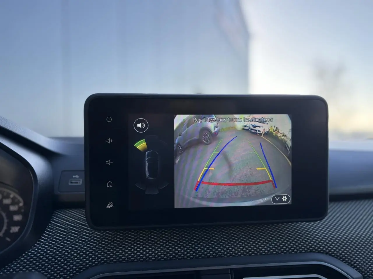 Écran tactile intérieur du Dacia Jogger gris schiste montrant la caméra de recul avec guidage de trajectoire coloré.