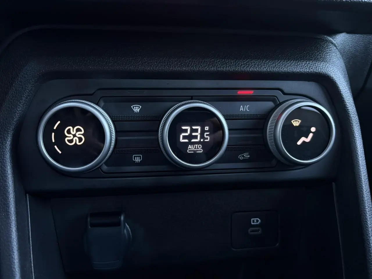 Gros plan sur les commandes de climatisation automatique du Dacia Jogger 2025, affichage digital à 23,5°C.