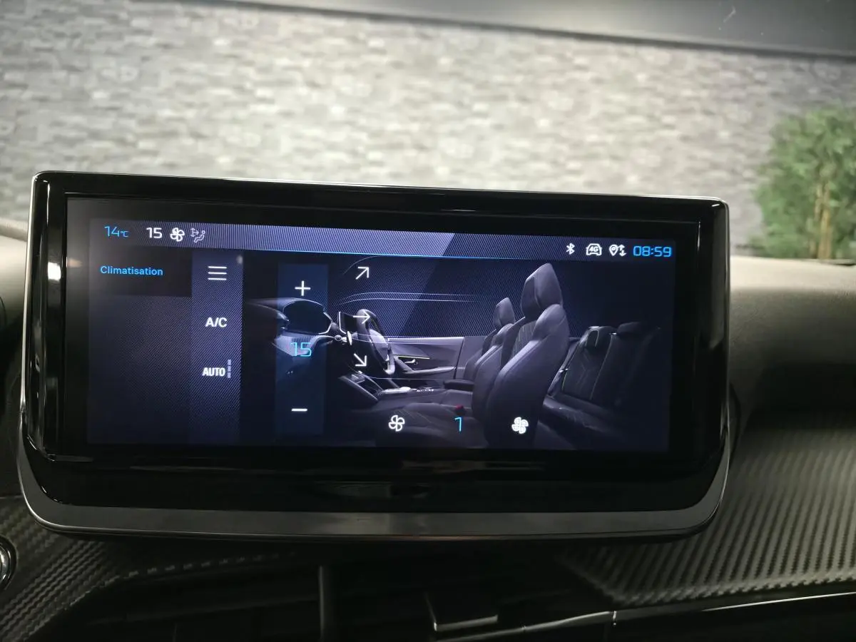 Écran tactile intérieur du Peugeot 2008 2025 affichant le réglage de la climatisation et la vue latérale des sièges noirs.