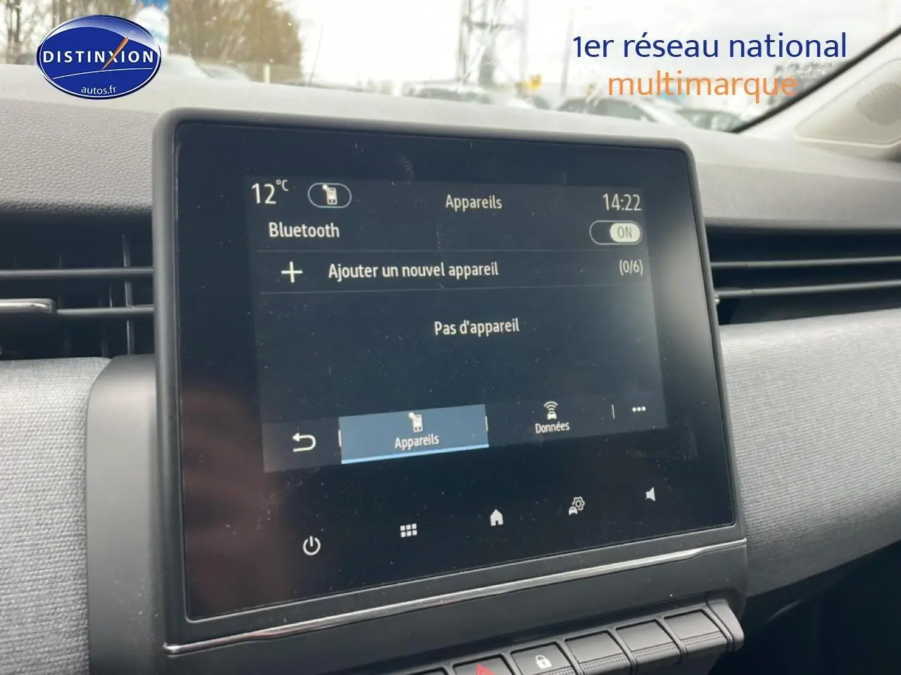 Écran tactile central de la Renault Clio V blanche, vue intérieure côté passager avec tableau de bord gris.