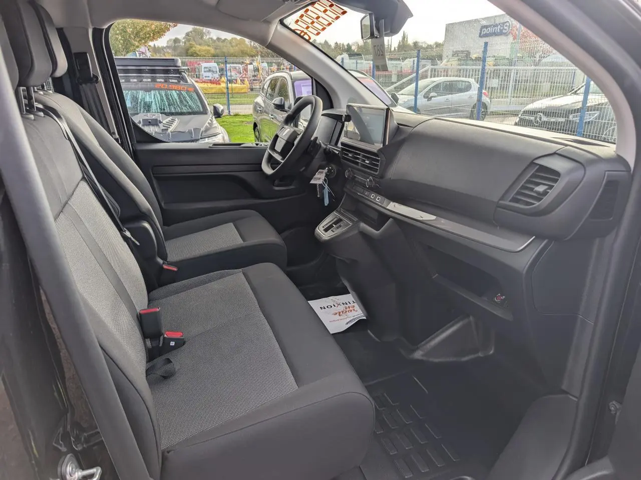 Intérieur avant du Peugeot Expert Fourgon noir 2025, vue côté conducteur montrant sièges tissu bi-ton et tableau de bord moderne.