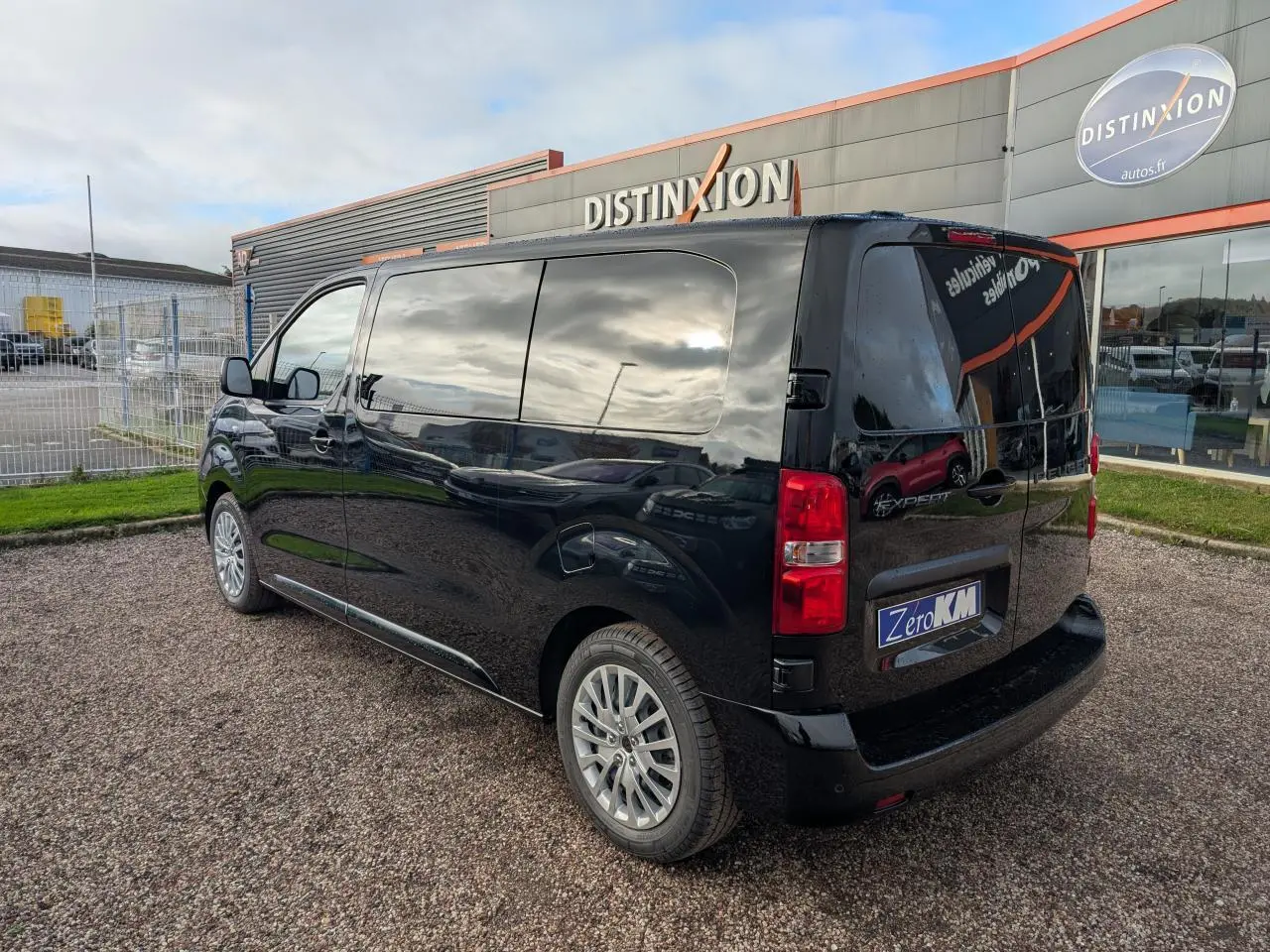 Vue 3/4 arrière droite du Peugeot Expert Fourgon noir 2025 avec vitres teintées et jantes tôle argentées.