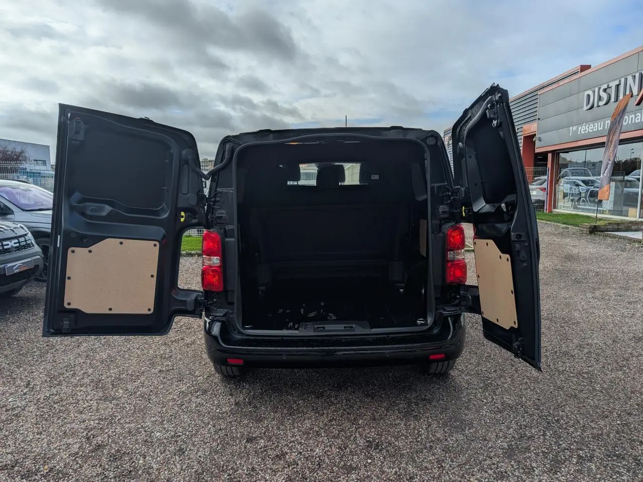 Vue arrière du Peugeot Expert Fourgon noir 2025 avec portes ouvertes montrant l'espace de chargement vide.