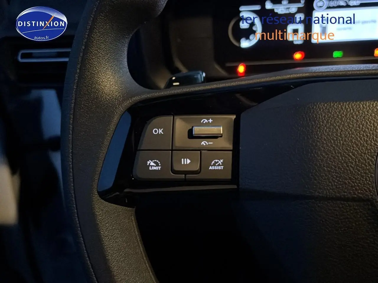 Gros plan sur les commandes multifonctions à gauche du volant du Citroën Berlingo Fourgon blanc, tableau de bord en arrière-plan.