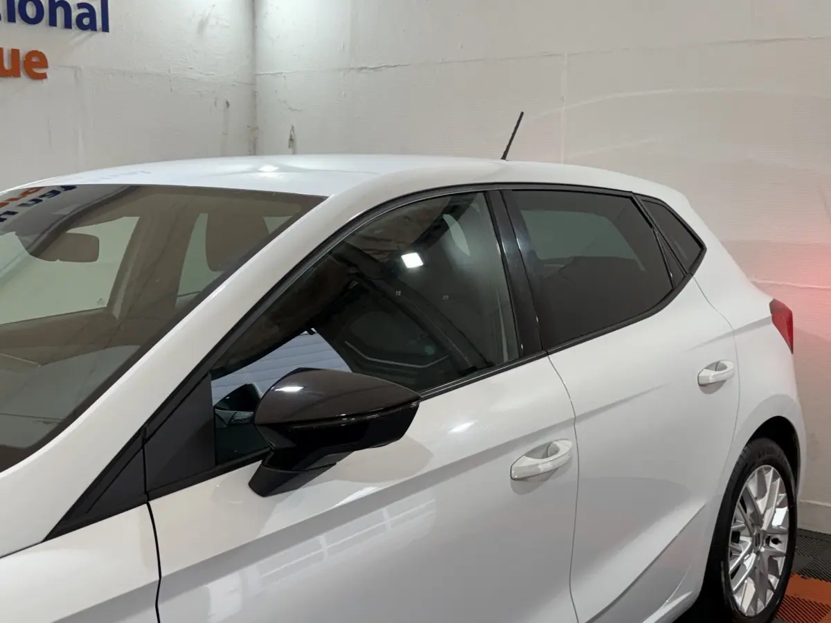 Vue latérale droite d'une SEAT Ibiza 1.0 TSI 110 FR blanche avec rétroviseur noir et vitres teintées.