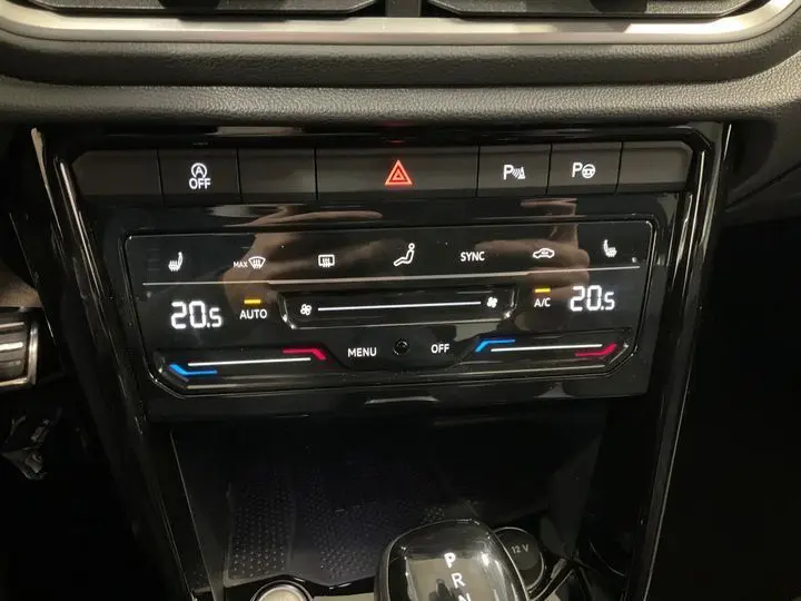 Vue rapprochée de la console centrale noire du Volkswagen T-Roc 2025, affichant la climatisation digitale à 20,5°C.