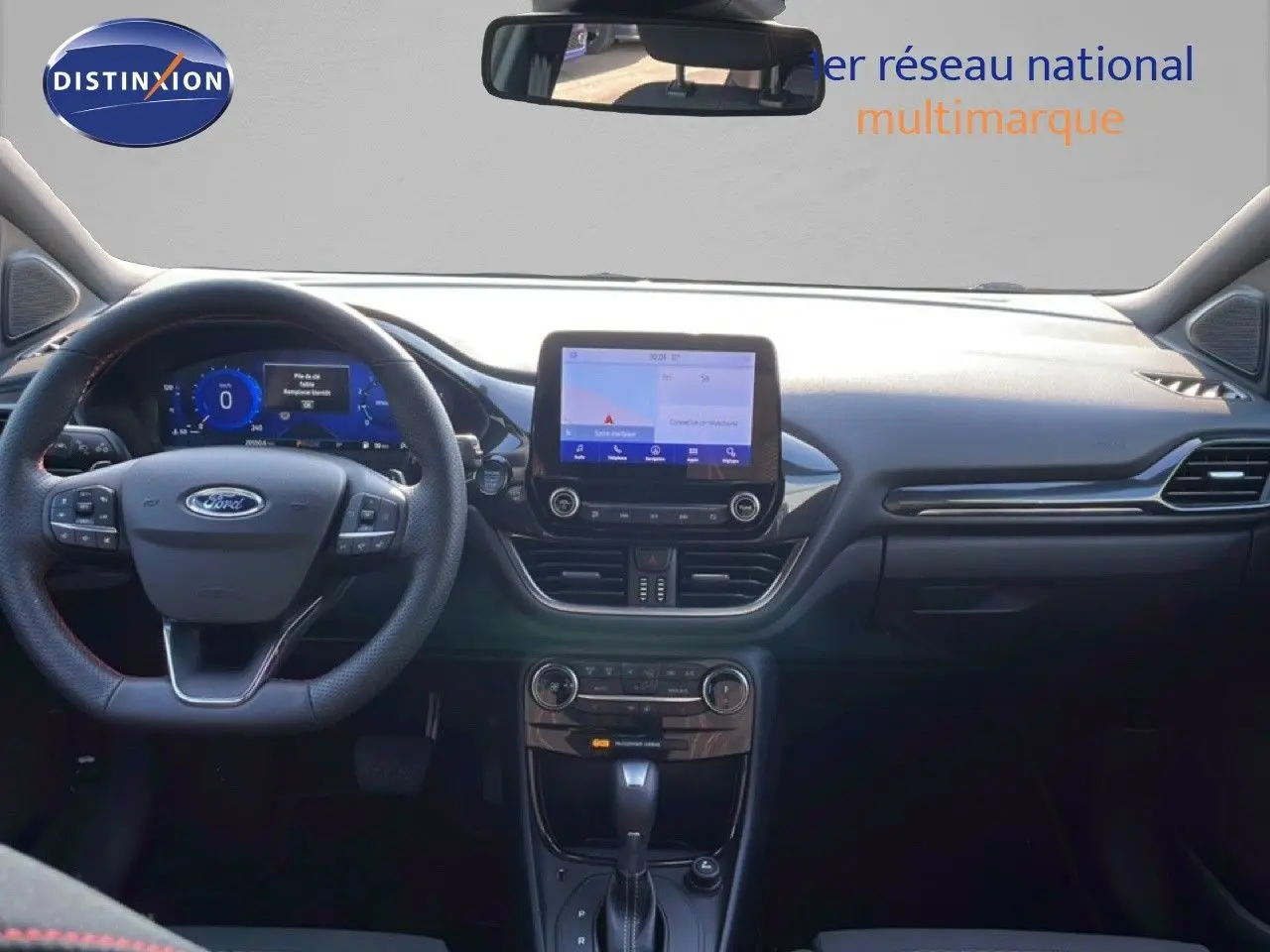 Vue intérieure frontale du tableau de bord noir d'une Ford Puma 2023 avec écran tactile et volant multifonction.