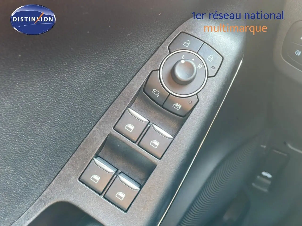 Gros plan sur les commandes des vitres électriques et rétroviseurs côté conducteur du Ford Puma noir Agate Metal 2023.