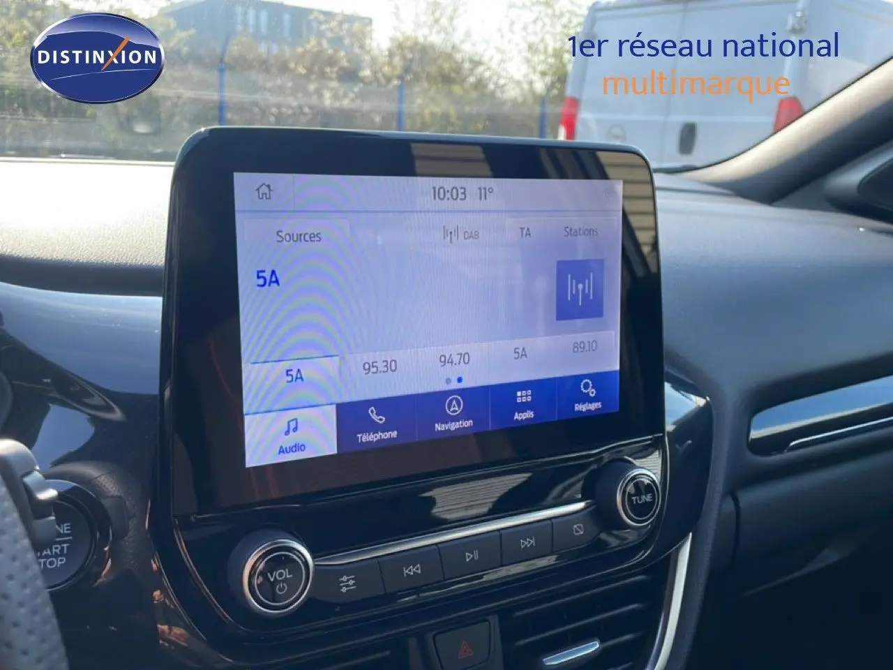 Vue intérieure du tableau de bord du Ford Puma 2023 noir agate, avec écran tactile central et commandes audio visibles.