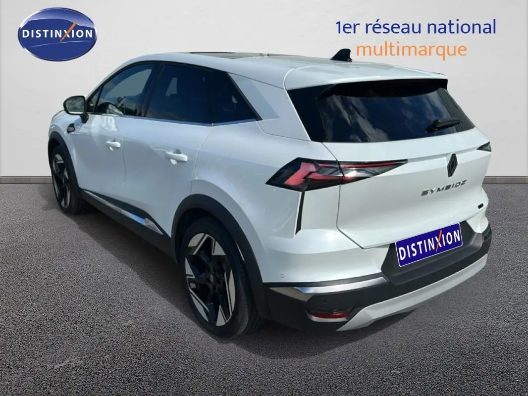 Vue 3/4 arrière droite d'une Renault SYMBIOZ blanche avec jantes alliage 19 pouces et vitres teintées.