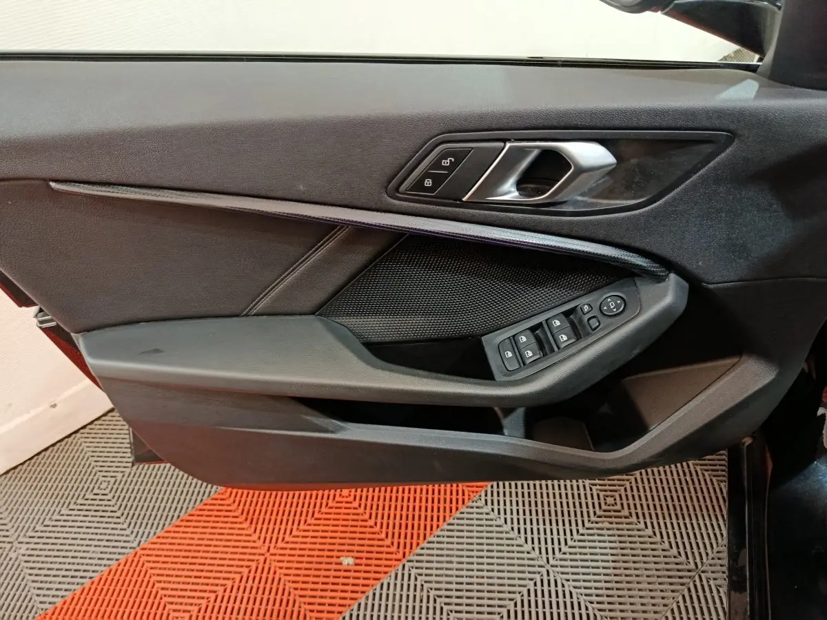 Vue rapprochée de la porte avant gauche noire de la BMW Série 1 118i Edition Sport avec commandes électriques.