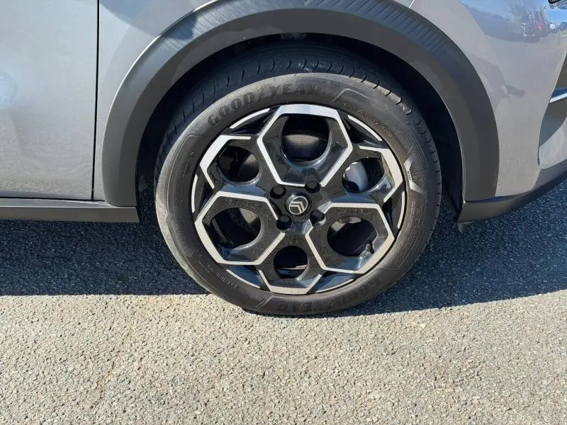 Gros plan sur la roue avant droite d'une Citroën C3 2025 gris Mercury avec jante alliage au design hexagonal.