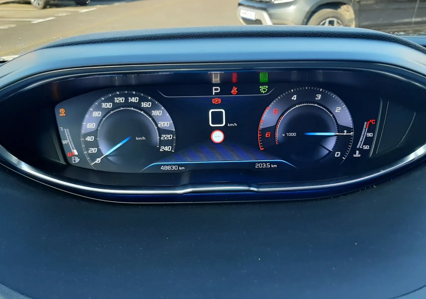 Vue rapprochée du tableau de bord numérique du Peugeot 3008, affichant vitesse, compte-tours et témoins lumineux.