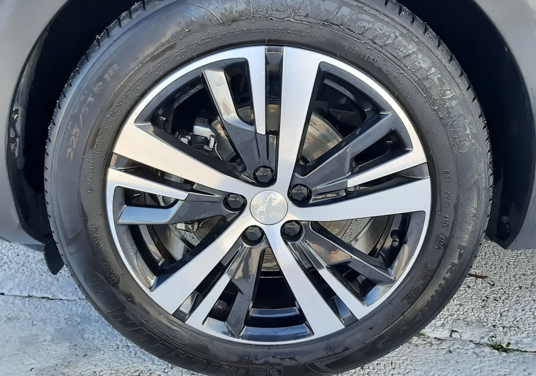 Gros plan sur la jante alliage bicolore noir et argent d’un Peugeot 3008 gris Amazonite, vue côté droit.