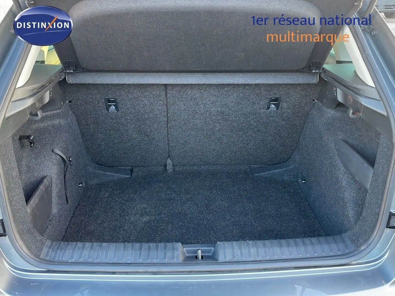 Coffre ouvert du Skoda Kamiq gris graphite métal 2024, vue arrière montrant l'espace de chargement vide et les finitions intérieures en tissu gris.