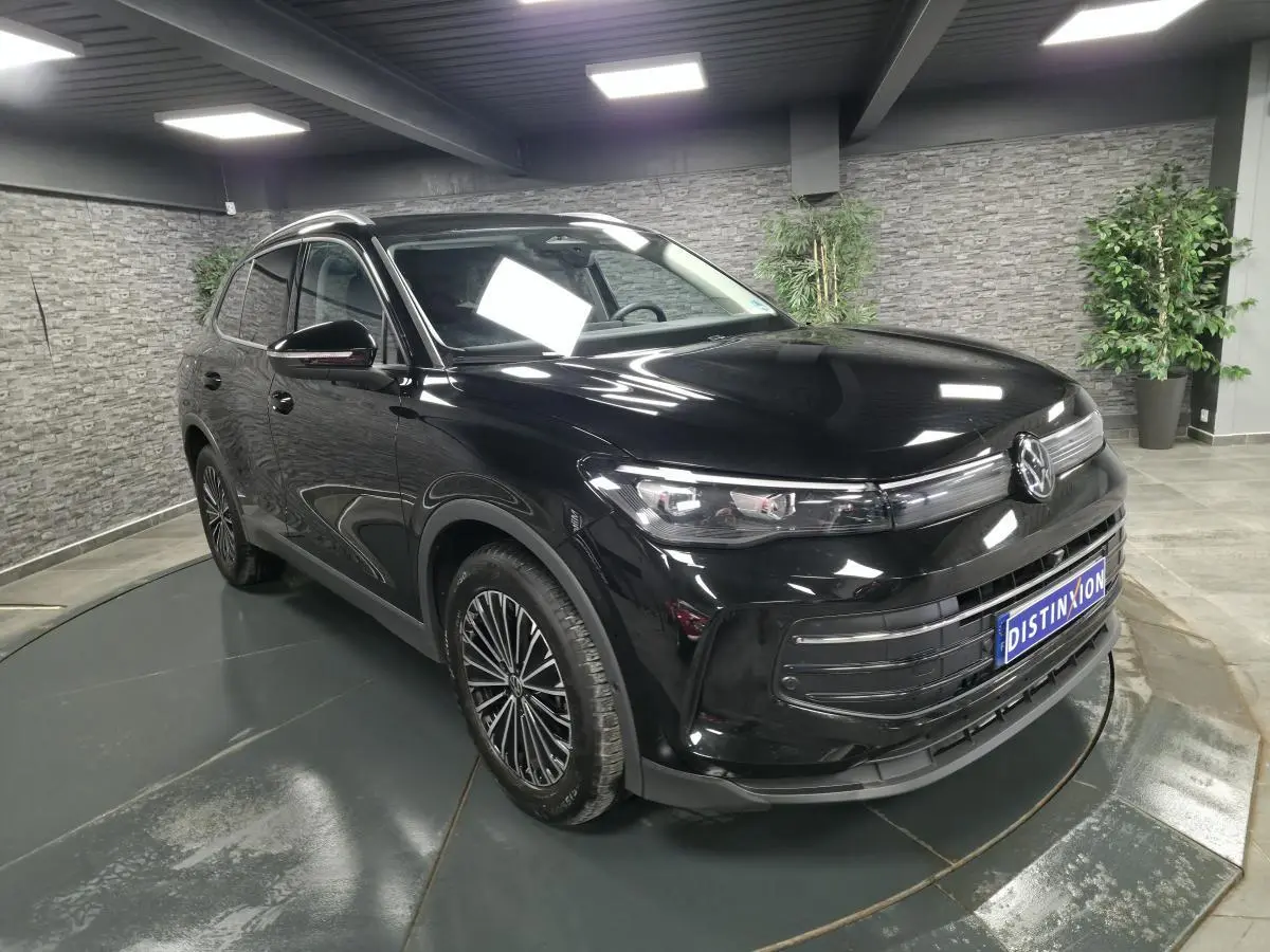 Volkswagen Tiguan noir en 3/4 avant droit, avec jantes alliage 18 pouces et calandre moderne brillante.