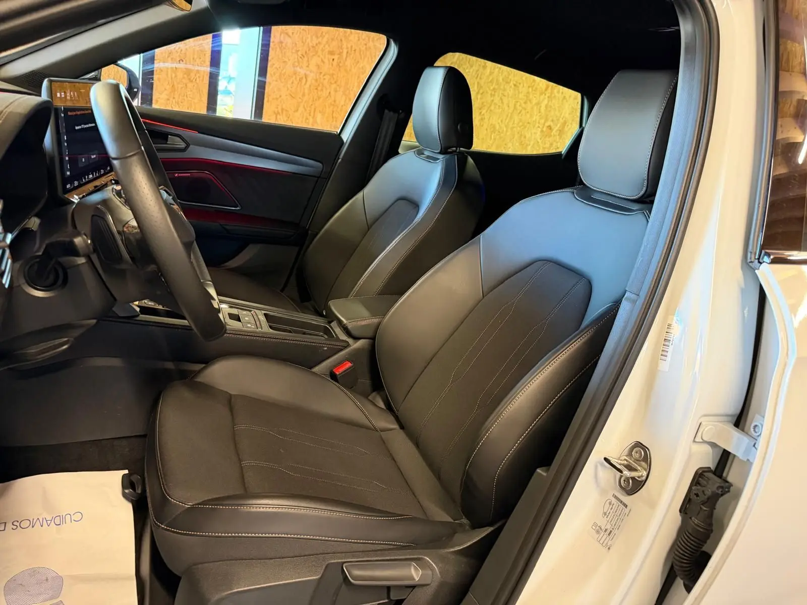 Vue intérieure côté conducteur du CUPRA Formentor blanc 2025, sièges en cuir noir avec surpiqûres blanches et tableau de bord moderne.