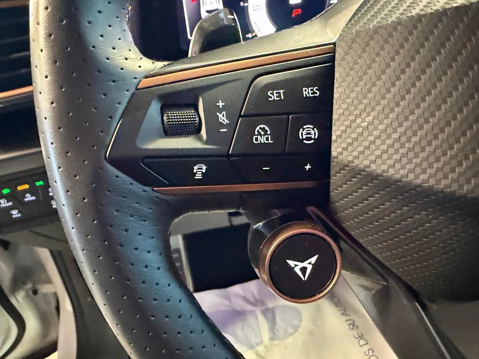 Gros plan sur le volant cuir perforé noir du CUPRA Formentor 2025 avec commandes de régulateur et logo CUPRA central.