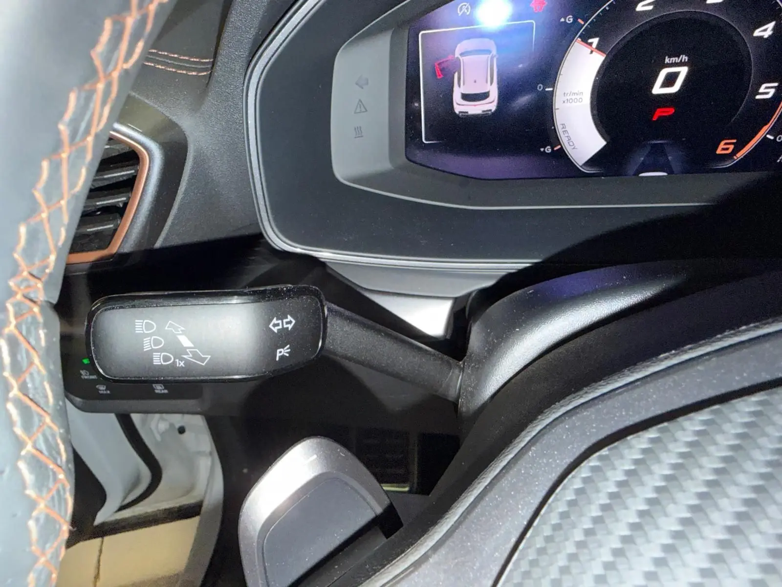 Gros plan sur le combiné d’instruments digital et la commande de clignotants dans l’habitacle du CUPRA Formentor blanc.