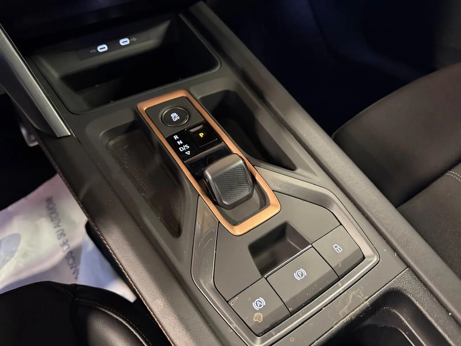 Gros plan sur la console centrale noire avec levier de vitesses automatique et cadre cuivre dans un CUPRA Formentor blanc.