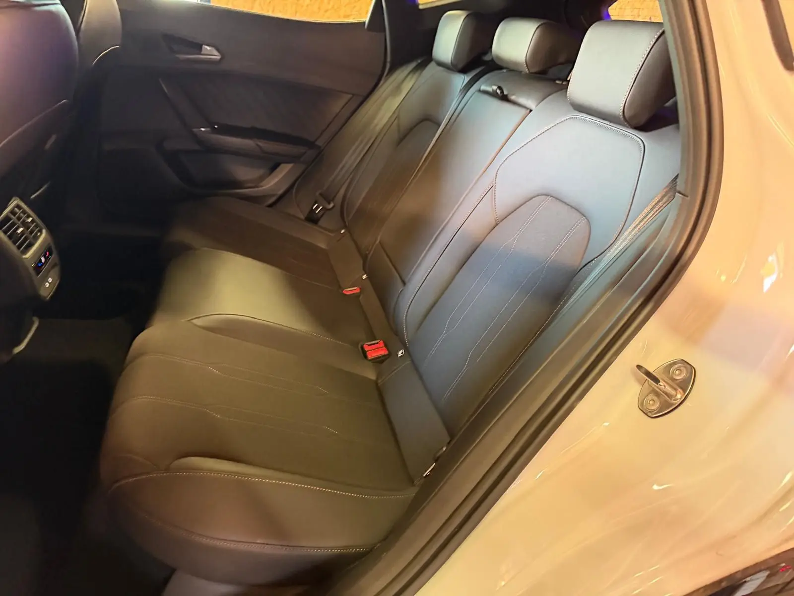 Vue intérieure côté droit sur la banquette arrière en cuir noir du CUPRA Formentor blanc 2025 avec portière ouverte.