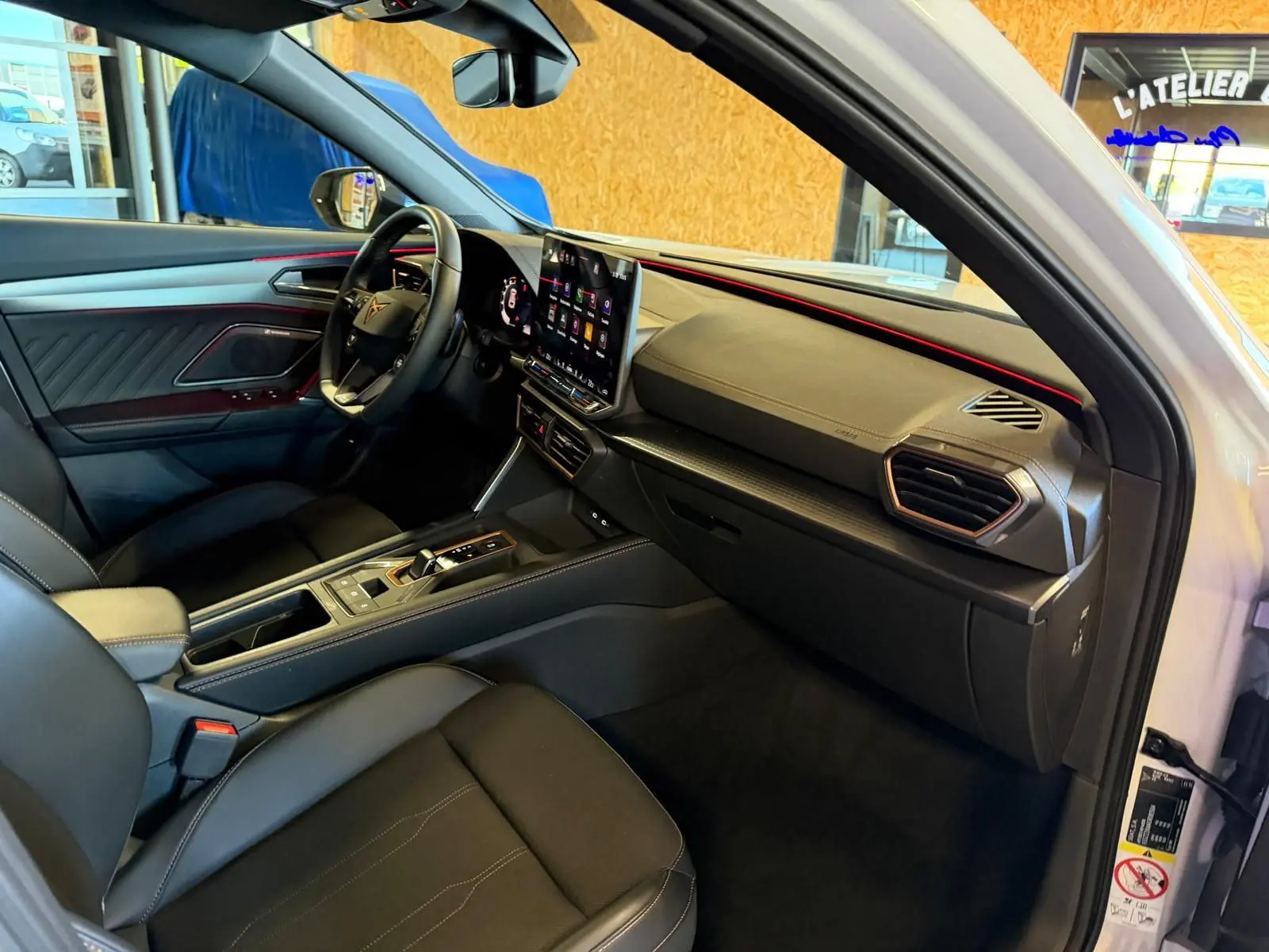 Intérieur avant droit du CUPRA Formentor blanc 2025, avec tableau de bord moderne et éclairage d'ambiance rouge.