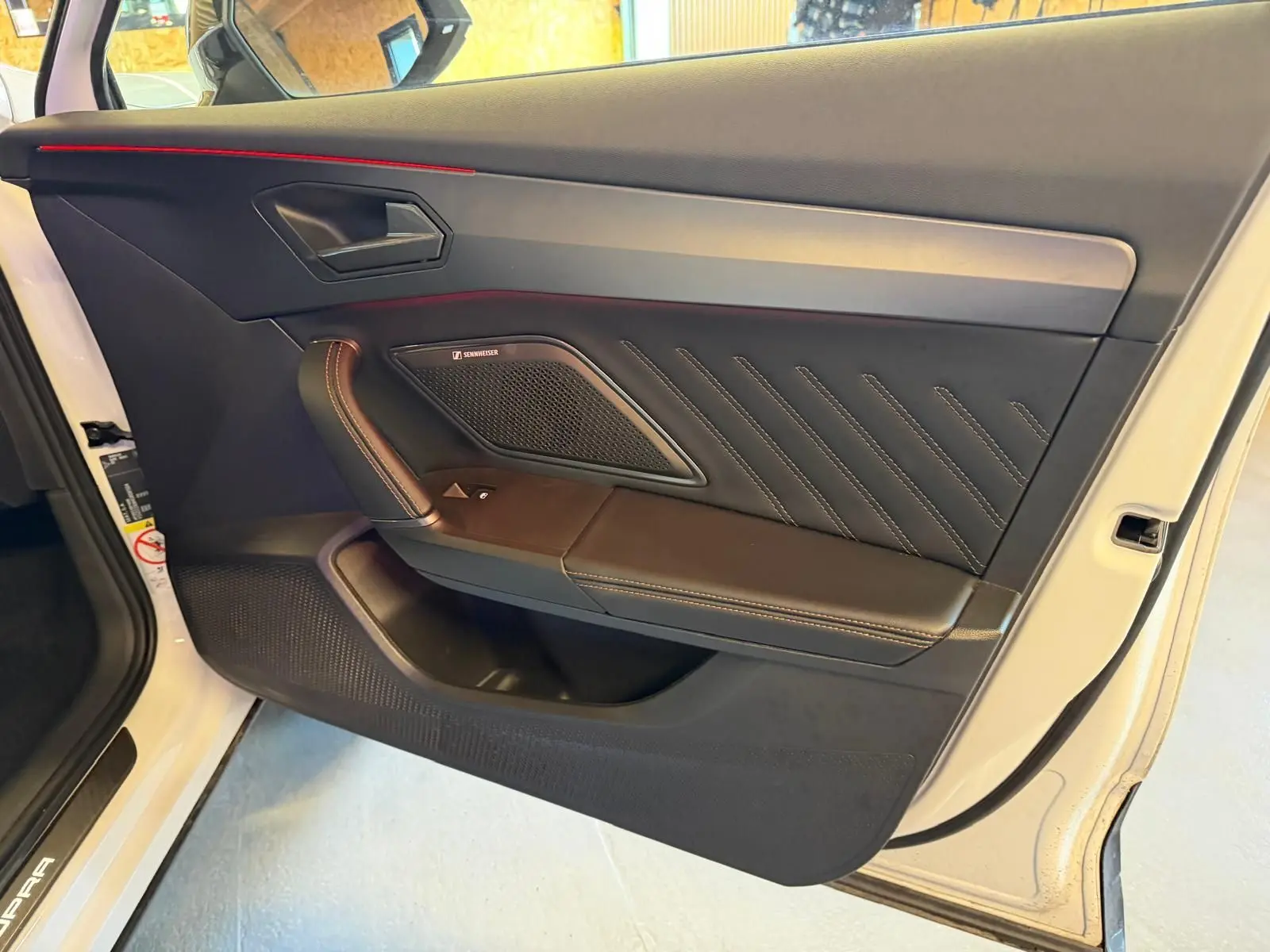 Vue rapprochée de la porte avant gauche blanche du CUPRA Formentor 2025 avec garniture noire et surpiqûres contrastées.