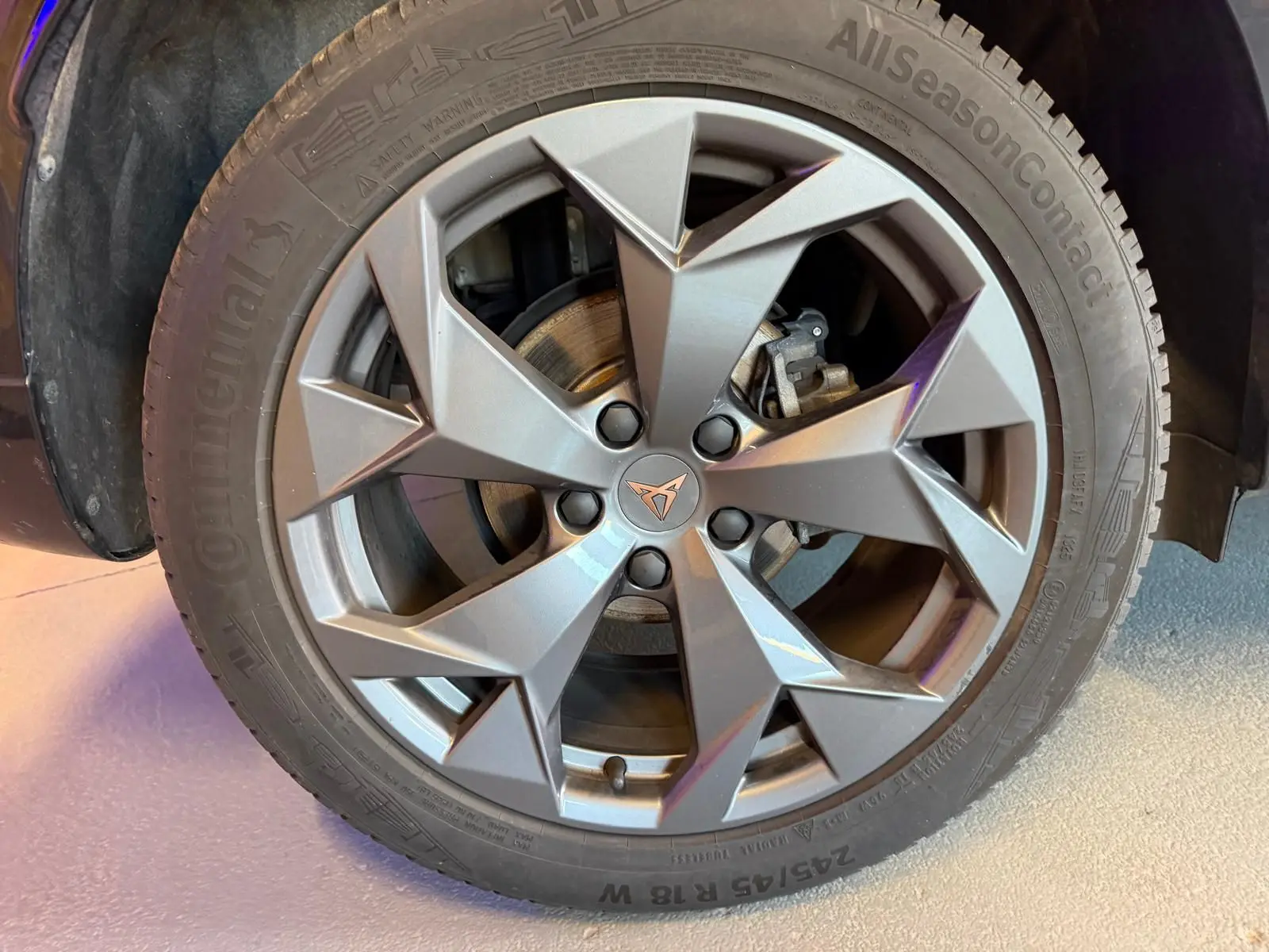 Gros plan sur la jante alliage grise à design géométrique du CUPRA Formentor blanc, avec logo CUPRA au centre.