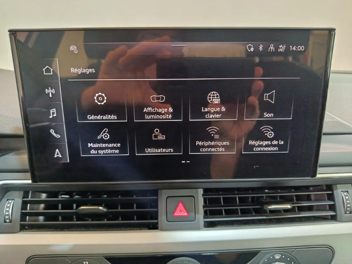Écran tactile central de l’Audi A4 35 TFSI 2024 affichant le menu réglages, avec tableau de bord gris visible.