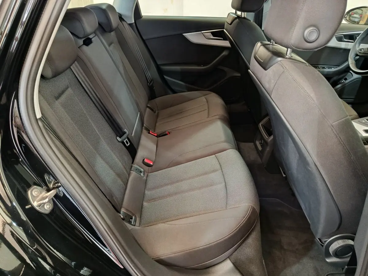 Vue intérieure côté gauche des sièges arrière en tissu gris foncé de l'Audi A4 35 TFSI Business Line noire de 2024.