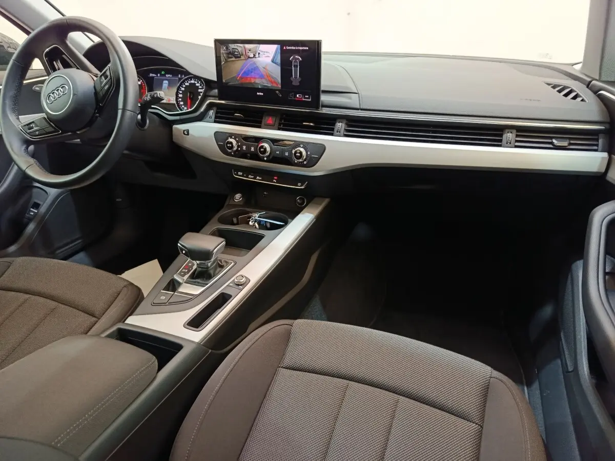 Intérieur Audi A4 35 TFSI 2024 vu côté conducteur, tableau de bord moderne avec écran central et volant cuir noir.