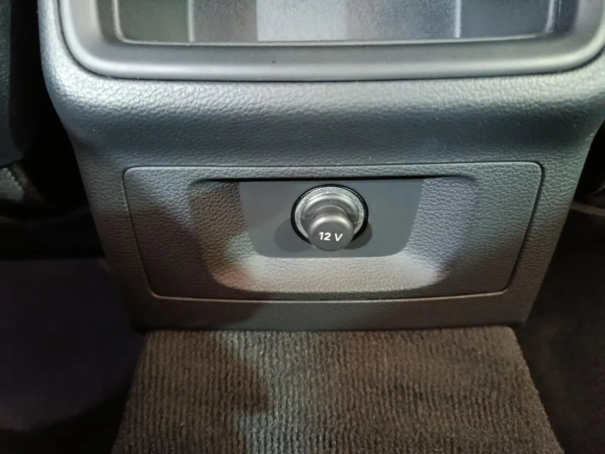 Prise 12V en gros plan sur la console centrale noire de l’Audi A4 35 TFSI Business Line 2024.