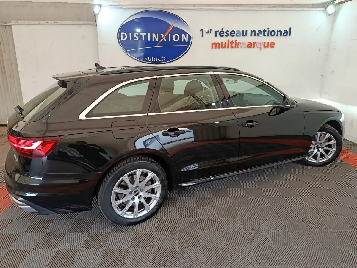 Audi A4 35 TFSI Business Line noire vue de profil côté droit dans un showroom avec jantes argentées.