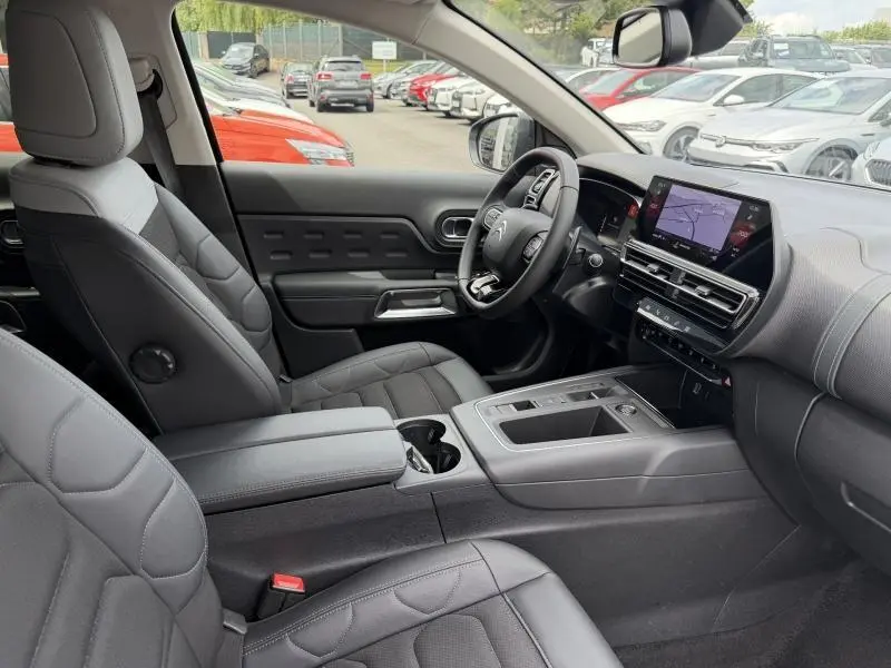 Intérieur noir du Citroën C5 Aircross 2024, vue côté droit sur sièges, volant cuir et écran tactile GPS.