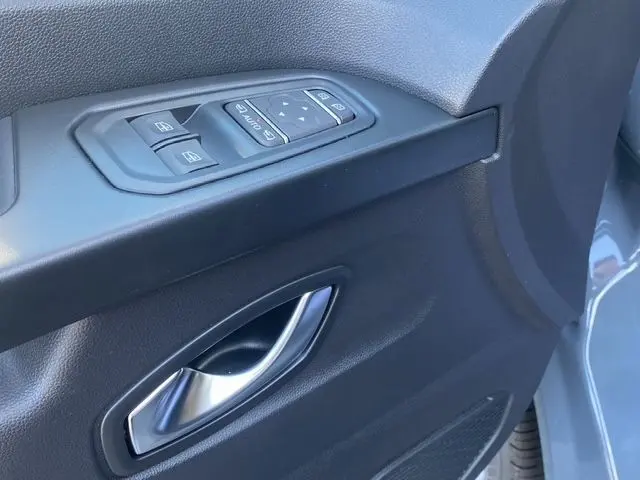 Poignée de porte intérieure côté gauche avec commandes des vitres sur Renault Trafic Gris Urbain vue rapprochée