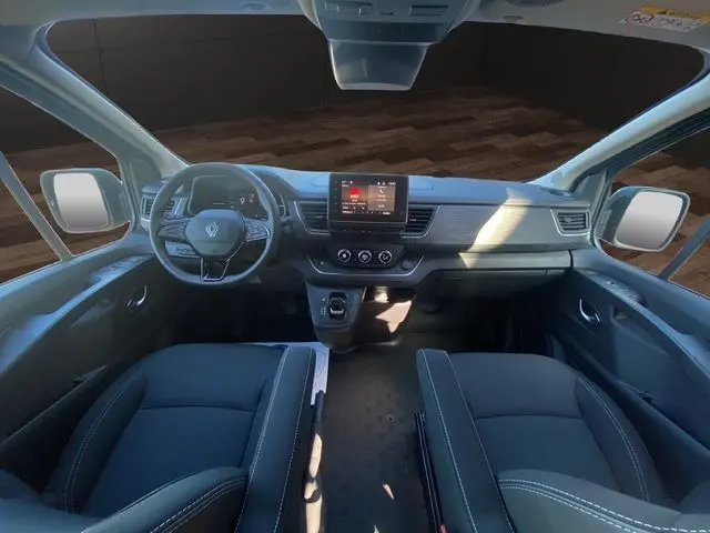 Vue intérieure avant du Renault Trafic Cabine Approfondie 2025, tableau de bord moderne avec écran tactile et sièges noirs en tissu.